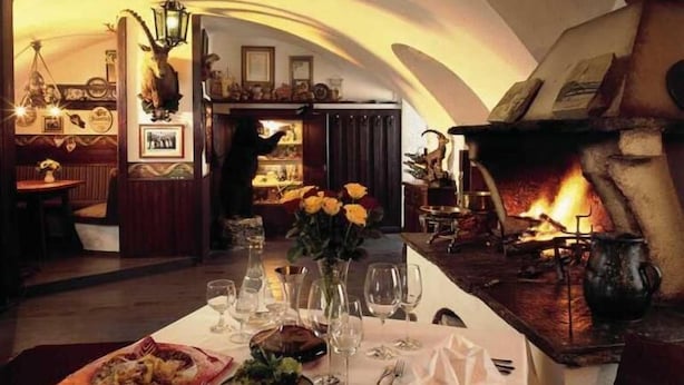 A dining area with a table set for two, a fireplace, and a warm ambiance. - Markterwirt (Altenmarkt im Pongau)