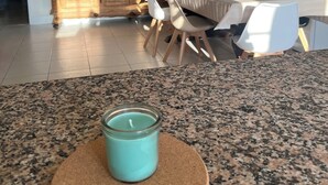 Una cocina con encimeras de granito, una mesa de comedor con sillas, un ventilador de techo y armarios de madera.