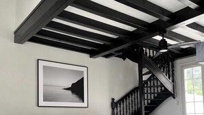 Una sala moderna con un sofá seccional gris, una mesa de centro y una escalera con barandilla negra.