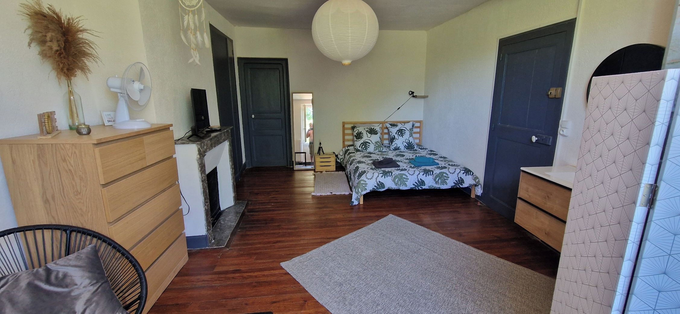 Een slaapkamer met een bed, een kaptafel en een stoel.