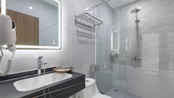 A modern bathroom with a glass-enclosed shower, a white toilet, and a vanity with a black countertop.