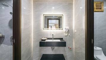 Un baño moderno con tocador, espejo y ducha.
