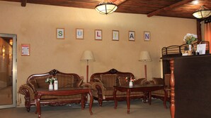 A room with two wooden sofas, a small table, and a decorative lamp. - Sultan Kyzyl-Kiya (Kyzyl-Kiya)
