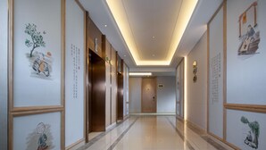 A hotel corridor with wooden paneling, artwork, and a polished floor. - Vienna Sleep International Hotel (Shenzhen)
