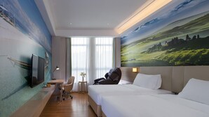 A hotel room with a bed, a desk with a chair, a TV, and a painting on the wall. - Vienna Sleep International Hotel (Shenzhen)