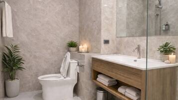 A modern bathroom with a toilet, sink, and shower.