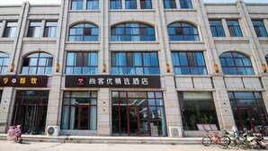 A multi-story building with large windows and a sign indicating a hotel. - Shankee Hotel (Suqian)