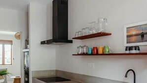 Una cocina moderna con una isla central, horno integrado y campana extractora de acero inoxidable.