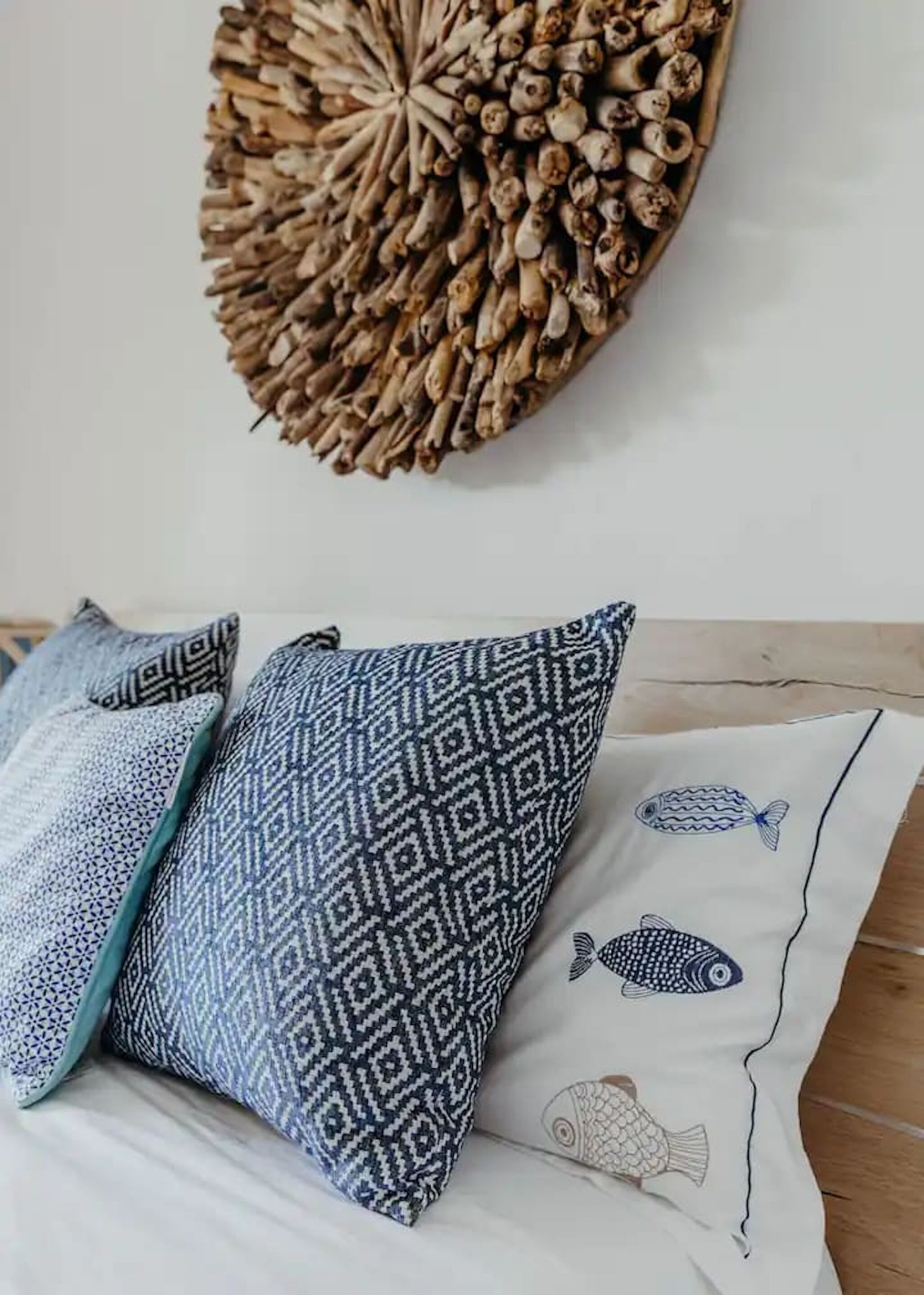 Een kamer met een kussen met patroon en een decoratie aan de muur.