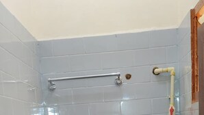 Un baño pequeño con inodoro, ducha y lavamanos.