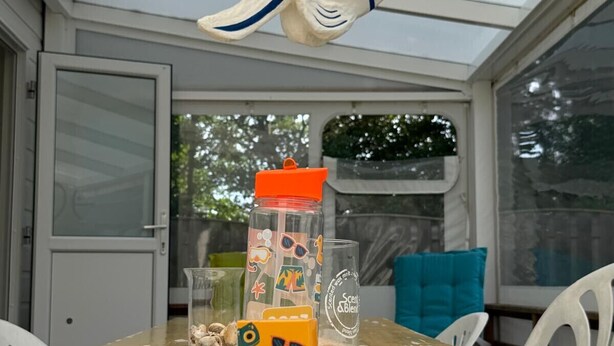 Ett matbord med en fiskformad dekoration, ett glas med en etikett och en liten orange låda med ett ansikte på.