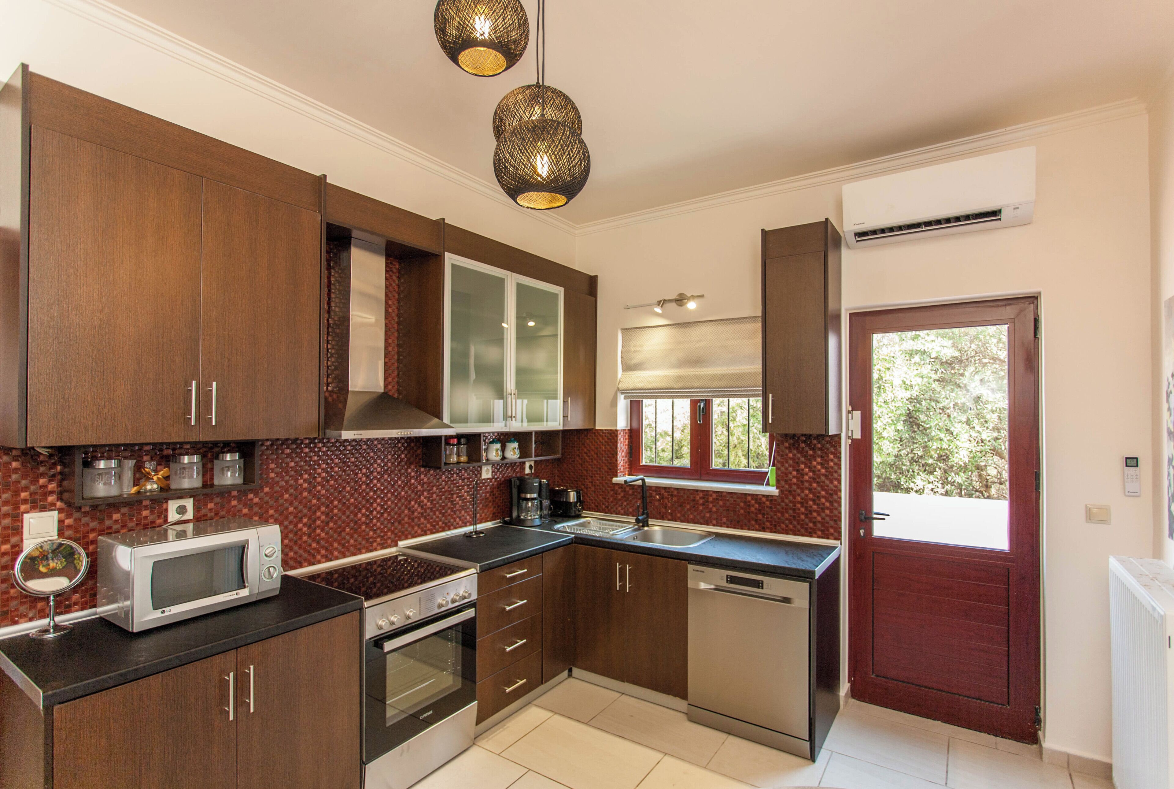 Una cocina moderna con armarios de madera, microondas, estufa y lavavajillas.