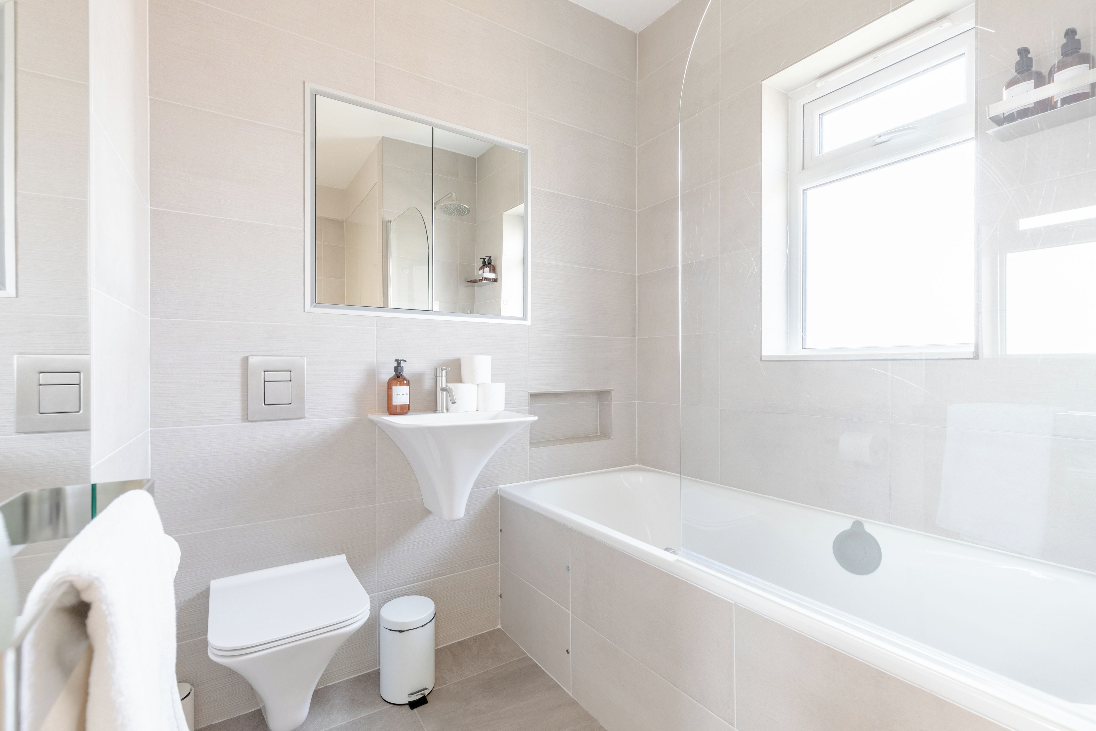A modern bathroom with a toilet, sink, and bathtub.