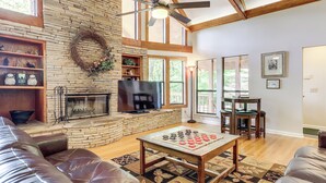 A living room with a fireplace, leather sofas, a coffee table, and a large window. - Access to 3 Pools, Private Hot Tub! Gatlinburg Gem (Gatlinburg)