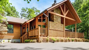 A wooden cabin with a porch, stone foundation, and a chimney. - Access to 3 Pools, Private Hot Tub! Gatlinburg Gem (Gatlinburg)