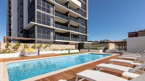 Un edificio moderno con piscina e poltrona prendisole.