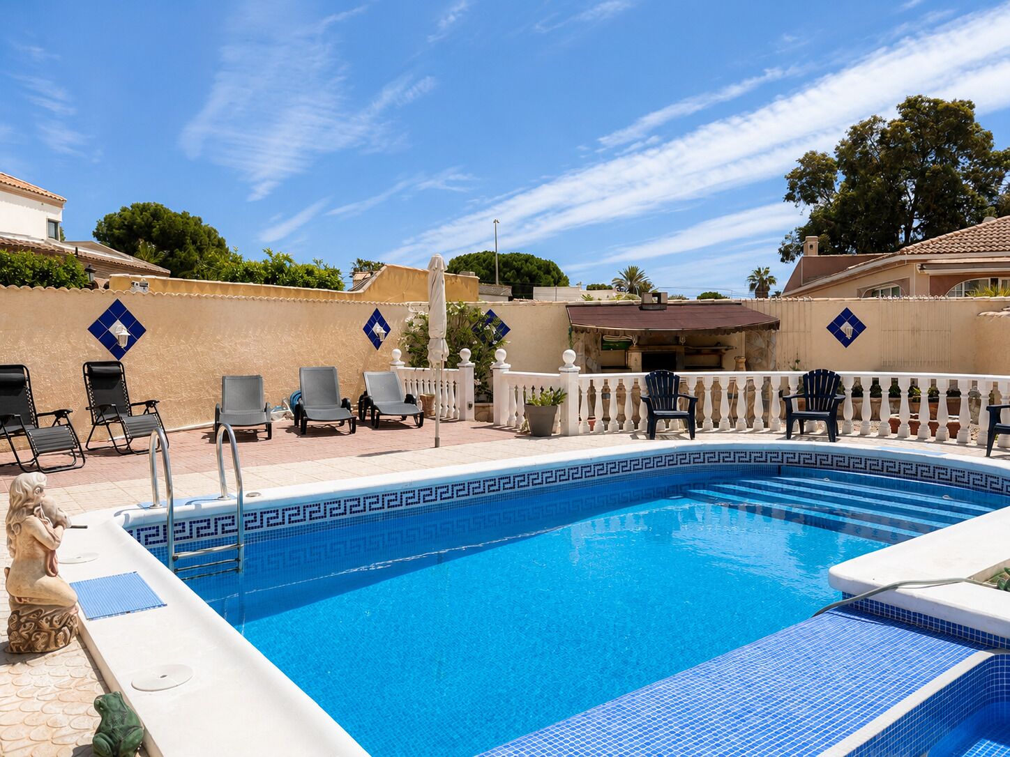 A swimming pool with lounge chairs and a decorative border.