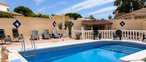 A swimming pool with lounge chairs and a decorative border.