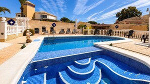 A swimming pool with a geometric tile pattern, surrounded by lounge chairs and a white fence. - Private Pool Villa in El Chaparral (El Chaparral)