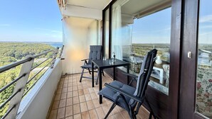 Ein Balkon mit Tisch und Stühlen, Blick auf die Landschaft und einer Brüstung.