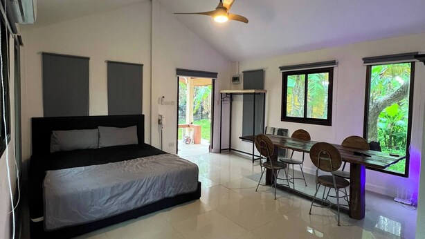 A bedroom with a bed, a ceiling fan, and a dining area with chairs and a table. - A peaceful cozy home, will truly refresh your soul (Maret)