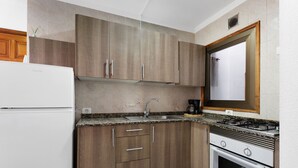 Eine Küche mit Holzausstattung, einem Edelstahlspülbecken, einem Gasherd und einem eingebauten Backofen.