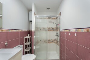 A bathroom with a shower, toilet, and sink. - Charming 2-Bedroom Apartment in Puerto de Santiago (Puerto de Santiago)