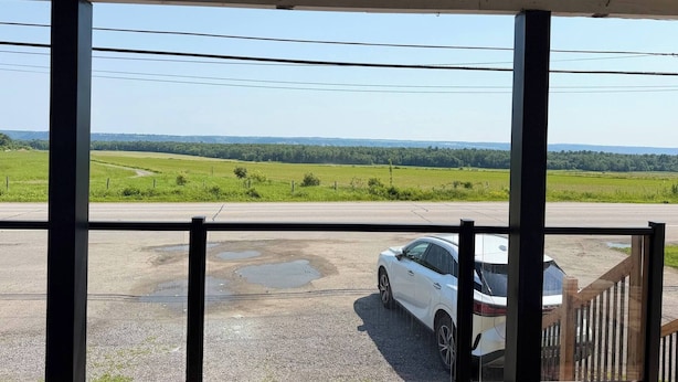 A view from inside a building with large windows overlooking a parking area with a white car. - Chris          Manor (Saint-Augustin-de-Desmaures)