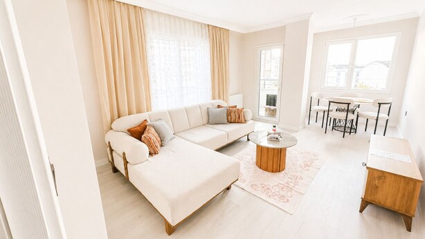A modern living room with a sofa, coffee table, and dining area. - Luxury 2+1 Apartment, 1st Floor – 15 Minutes to the Airport (Arnavutköy)