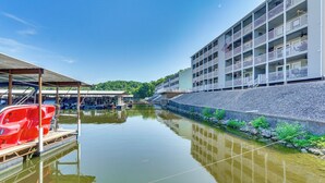 Un hôtel situé au bord de l’eau, doté d’une piscine, d’un espace abrité et d’un bâtiment avec des balcons.