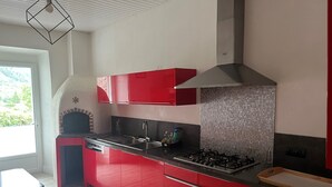Eine moderne Küche mit roten Schränken, einem Gasherd und einem eingebauten Backofen.