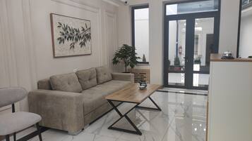 A modern living room with a sofa, a coffee table, and a potted plant.