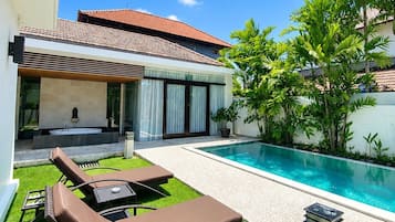 A modern house with a swimming pool, outdoor seating, and a garden.