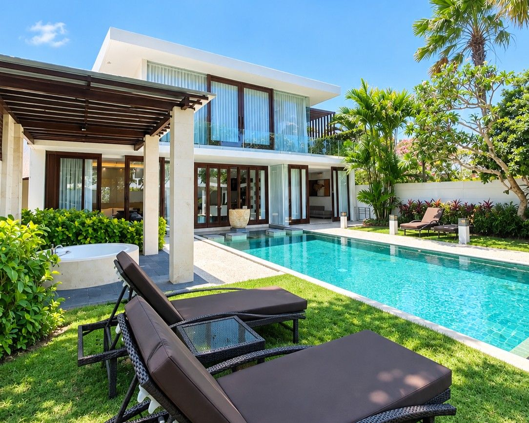 Una casa moderna con piscina, sillas de descanso y un patio cubierto.