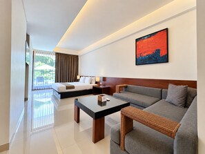 Ein modernes Hotelzimmer mit Bett, Sofa und Esstisch.