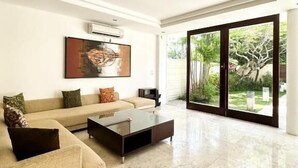 Una sala de estar moderna con un sofá, una mesa de centro y un ventanal grande.