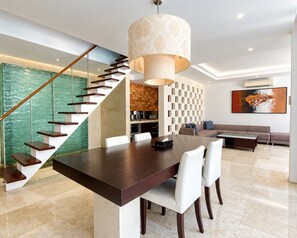 A modern interior with a dining area, staircase, and living space. - The Wangsa Hotel and Villas Nusa Dua (Nusa Dua)