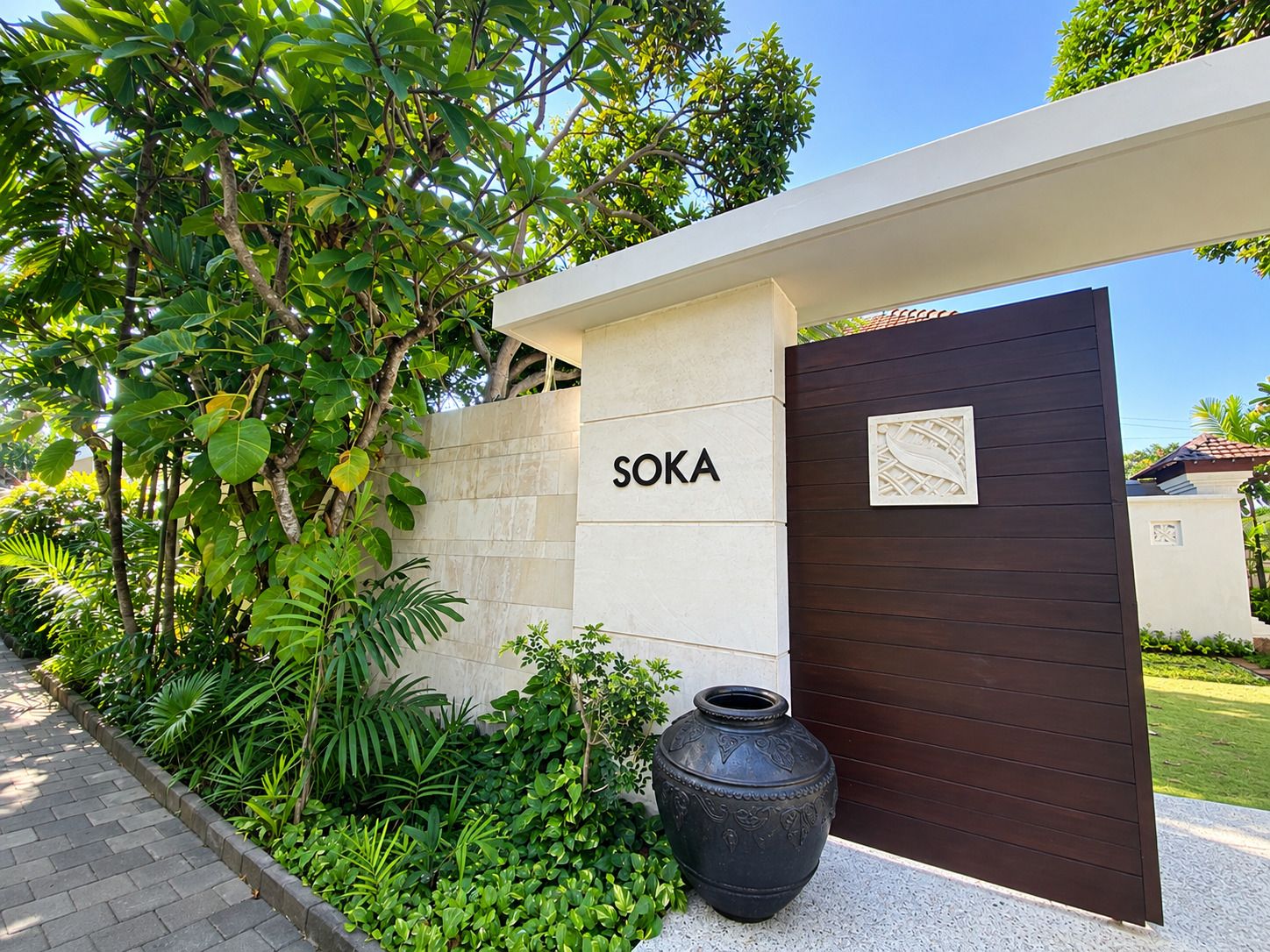 A modern entrance with a sign reading 'SOKA' and a decorative metal gate.