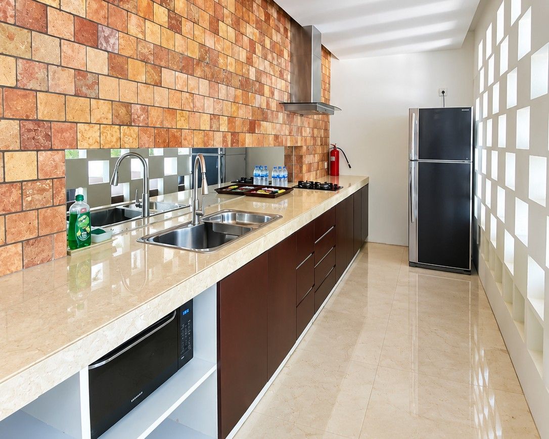 A kitchen with a tiled backsplash, stainless steel appliances, and a modern design.