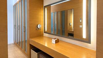 Habitación de hotel con tocador de madera, un espejo grande y un armario empotrado con puertas correderas.