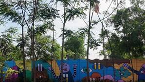 Uma piscina com um mural colorido na parede ao fundo.