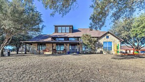 A two-story house with a stone facade, large windows, and a covered patio area. - Private Pool: Spacious & Vibrant Argyle Villa! (Argyle)