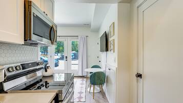 A compact kitchen with a microwave, stove, and dining area with a table and chairs.