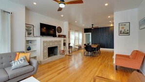 A modern living room with a fireplace, a dining area, and a sofa. - Pool Table! Pet-Friendly Haven 6 Mi to Rate Field (Chicago)