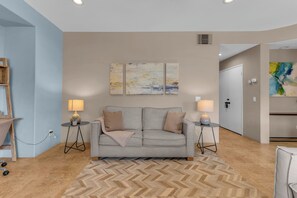 A modern living room with a sofa, two side tables, and a herringbone-patterned rug. - Desert Sanctuary | Pool, Spa & Sleeps 12 (Indio)