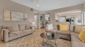 A living room with two sofas, a coffee table, and a herringbone-patterned rug. - Desert Sanctuary | Pool, Spa & Sleeps 12 (Indio)