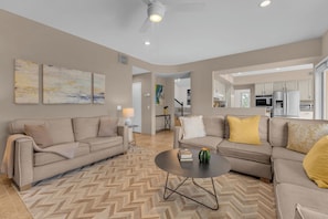 Ein Wohnzimmer mit zwei Sofas, einem Couchtisch und einem Teppich mit Fischgrätmuster.