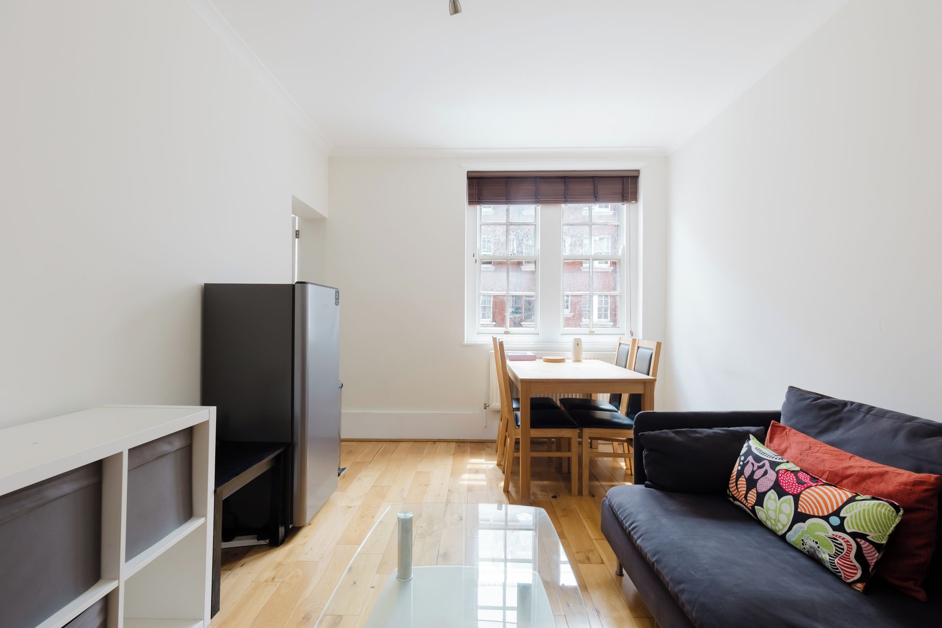 A compact living space with a kitchenette, a dining area, and a sofa.