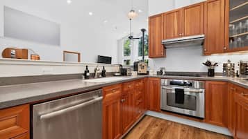 A modern kitchen with wooden cabinets, stainless steel appliances, and a dishwasher.