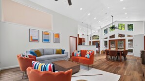 Ein modernes Wohnzimmer mit einer Couch, Sesseln, einem Couchtisch und Kunstwerken an der Wand.